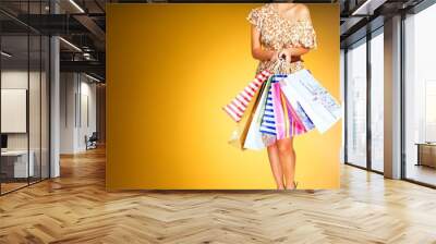 Young woman with shopping bags on  background Wall mural