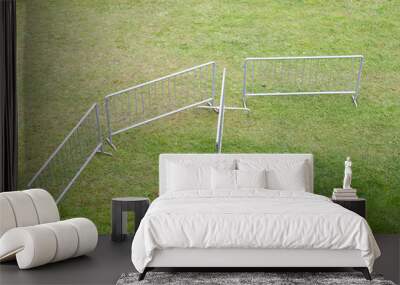 Mobile metal fencing. Steel portable fence. Metal fences, collapsible metal barriers on the grass. Wall mural