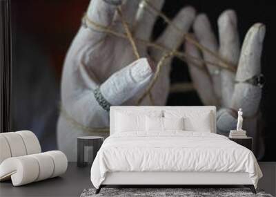 bound hand in white paint with rings on the black background Wall mural