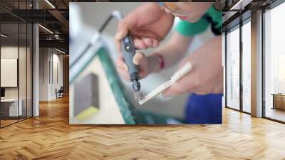 father hands Closeup photo teaching son tinkering, using straight grinder. Classes for young carpenter pollish wood. Toy weapon Shuriken making. Dreaming future profession. child woodcarving lesson Wall mural