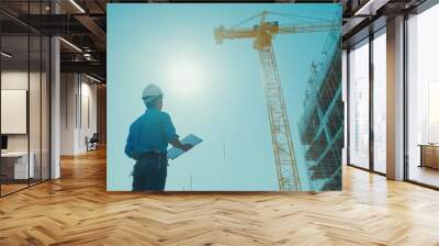 construction worker inspecting site with crane in background Wall mural