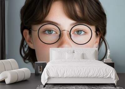 young woman with glasses looking at camera Wall mural