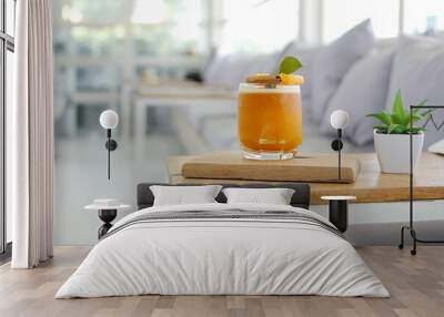 glass of orange juice on a wooden table In a white coffee shop Wall mural