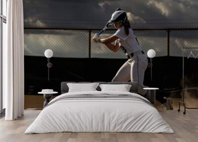 action shot of female softball player swinging a bat. Wall mural