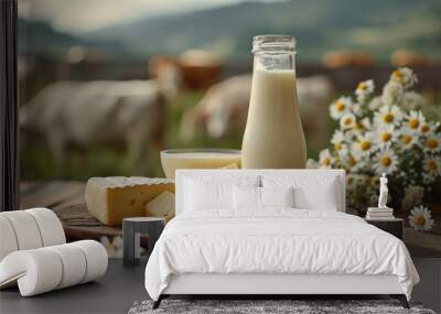 A bottle of milk, a glass of milk and a plate of cheese on the table in front of the cow field. Wall mural