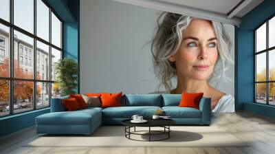 A woman with gray hair and blue eyes is looking at the camera Wall mural