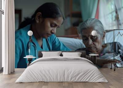 Indian nurse, blue uniform, checks the pressure of a senior woman on a bed in the back of the house. Wall mural