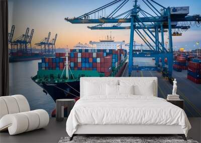 A container ship at a dock with a quay crane. The ship is carrying numerous container boxes. Business commercial trade global cargo freight shipping logistic and transportation worldwide overseas. Wall mural