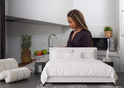 Side view of young female preparing healthy sandwiches for breakfast in light modern home kitchen Wall mural