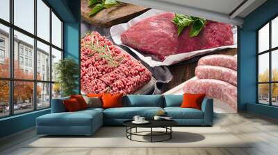 Different types of fresh raw meat on dark wooden background. Wall mural