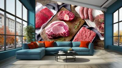 Different types of raw meat on dark wooden background. Wall mural