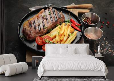 Striploin beef steak with french fries on dark background. Wall mural