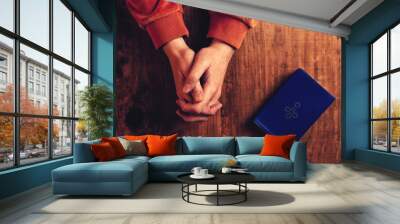 Christian woman praying with hands folded Wall mural