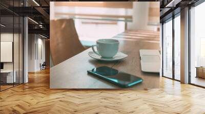 Coffee cup on home office desk between laptop computer and mobile smart phone Wall mural