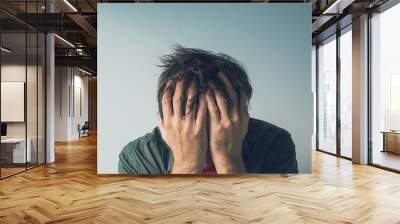 Disappointed man crying with head in hands Wall mural