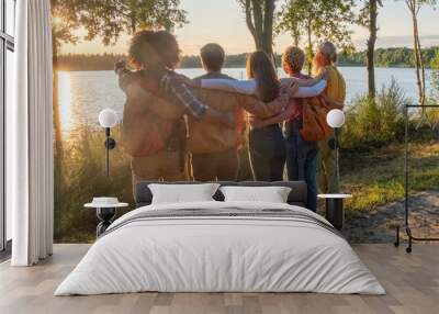 Five multiracial Young millennial friends on a hike celebrate reaching a summit near the coast, watching the beauty of nature and the sunsetfull length, side view. High quality photo Wall mural