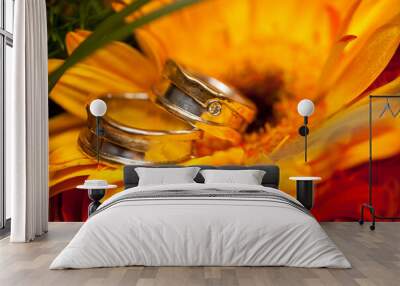 Wedding rings on a bright orange gerbera flower. High quality photo Wall mural