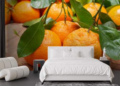 Fresh ripe organic mandarins with green leaves on natural olive wood like background. Wall mural