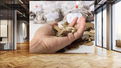 A gold coin in a woman's hand, she is collecting coins to spend on her daily life, losing her job because of the coronavirus. Wall mural