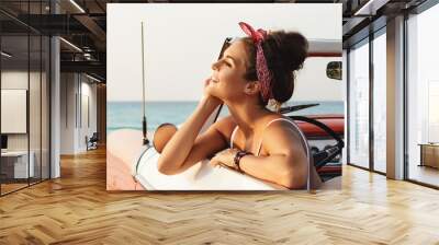 Beautiful and happy woman inside retro cabriolet car Wall mural