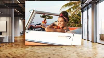 Beautiful and happy woman inside retro cabriolet car Wall mural