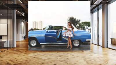 Beautiful woman driving a retro convertible car Wall mural