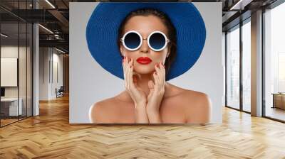 Beautiful woman wearing blue hat and sunglasses is ready for vacation Wall mural