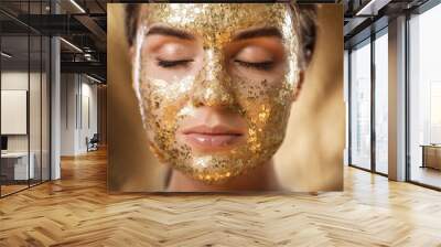 Beautiful woman with golden shining mask on her face for skin treatment Wall mural