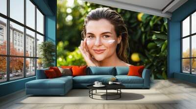 Beautiful woman with moisturizing cream under her eyes Wall mural