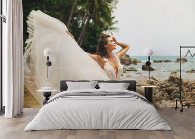 Bride wearing beautiful wedding dress on the tropical beach Wall mural