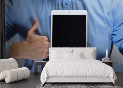 Man in blue shirt holding white tablet pc Wall mural