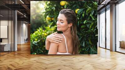 Portrait of beautiful woman with smooth skin against lemon trees Wall mural