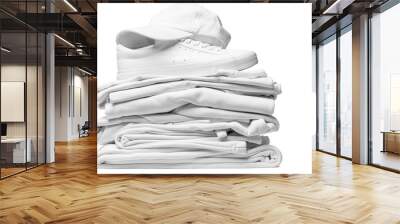 Stack of white clothes, trainers and baseball cap on white background Wall mural