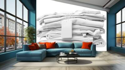 Stack of white clothes with a blank garment tag on white background Wall mural