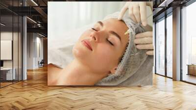 Woman during biorevitalization procedure in aesthetics medical clinic Wall mural