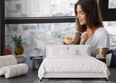 Young woman eating breakfast at morning Wall mural