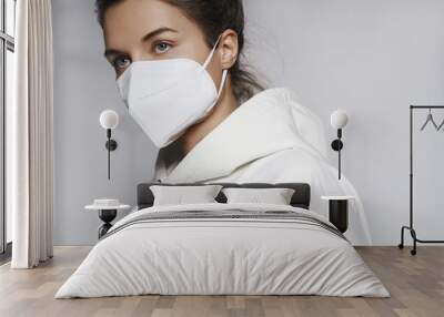 Young woman wearing white hoodie and ffp2 respirator mask Wall mural