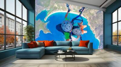 Paragliding in the sky. Paraglider tandem flying over the sea with blue water and mountains in bright sunny day. Aerial view of paraglider and Blue Lagoon in Oludeniz, Turkey. Extreme sport. Landscape Wall mural