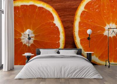 The half-cut orange. Two halves of juicy ripe orange on a wooden table Wall mural