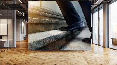 Motivation and challenging Career Concept. Steps Forward into a Success. Low Section of Businessman Walking Up on Staircase. Male in Black Formal Dress Wall mural