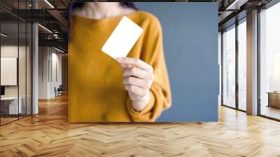 Woman holding blank business card Wall mural