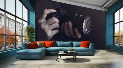 Young Photographer Woman using Camera to Taking Photo. Dark Tone. Selective Focus on Hand Wall mural