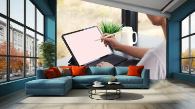 waman using digital tablet with stylus pen and smart keyboard Wall mural