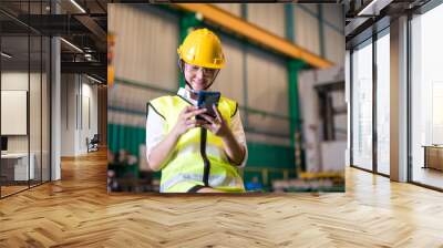 Factory smiling worker using phone during break Wall mural