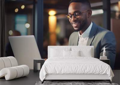 Handsome young businessman sitting office and working on laptop computer. Smiling black man using laptop. Professional african american CEO managing investment strategy. Wall mural