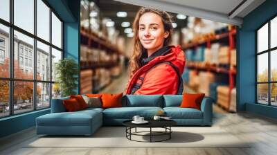 Portrait of happy young woman warehouse worker wearing safety jacket looking at camera.
 Wall mural