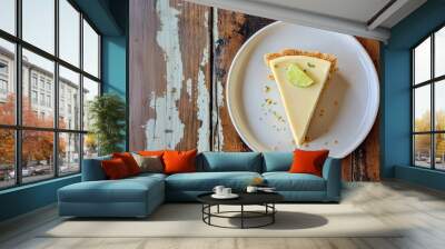 A slice of key lime pie with garnish of keylime and mint leaves on top of a white plate.  Wall mural