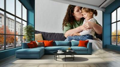 A mother lovingly kisses her daughter as they share a moment of creativity at home together. Wall mural