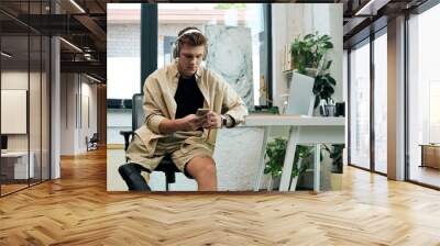 A talented young man with a prosthetic leg focuses on his tasks in a stylish modern office space. Wall mural