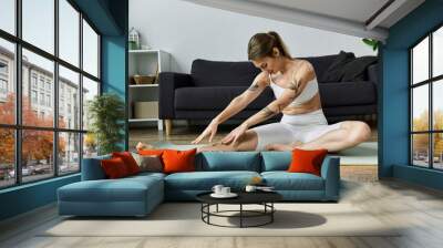 A young woman with vitiligo stretches on a yoga mat in a modern apartment, focusing on her breath and finding peace amidst a busy day. Wall mural